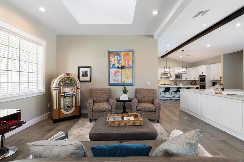 Cozy lounge with plush armchairs, natural light, and a fun vintage jukebox.