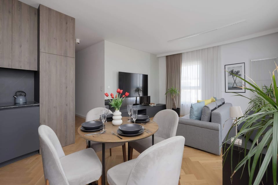 An open-plan dining and living area connected to a compact kitchenette. Modern furnishings create a comfortable atmosphere.
