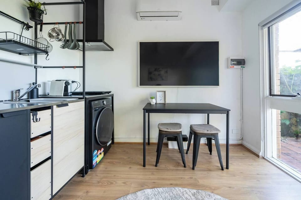 Enjoy casual meals beneath the wall-mounted TV before settling in for a quiet evening indoors surrounded by peaceful garden surrounds.