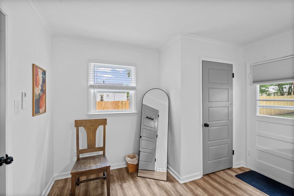 King bedroom entrance with closet, natural light and stylish full-length mirror