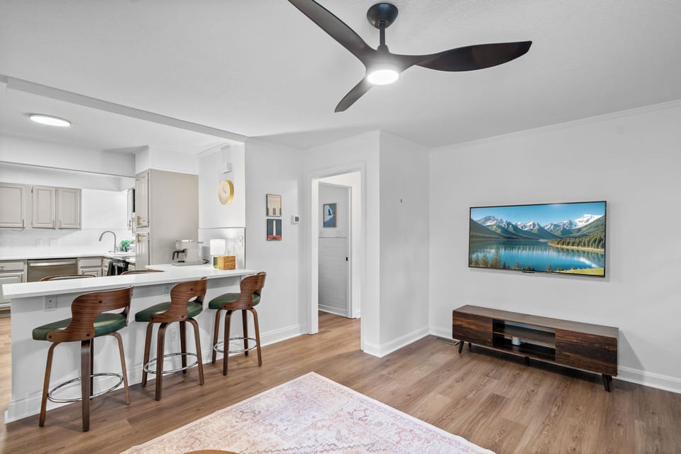 Open living space with breakfast bar, TV, and modern finishes