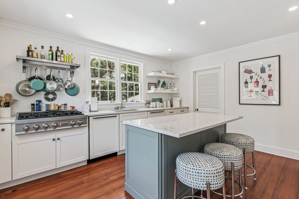 Your dream kitchen awaits with modern appliances, charming coastal-style design, an island for gathering, and bright natural light streaming through classic windows.