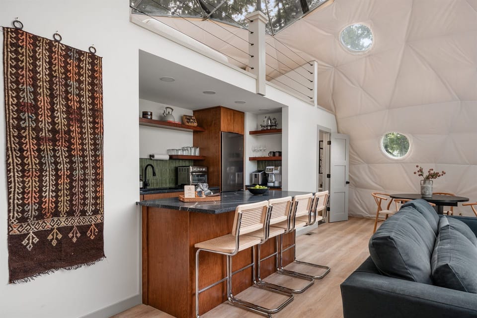 Unique dome retreat with modern kitchen, island seating, and bright airy lounge