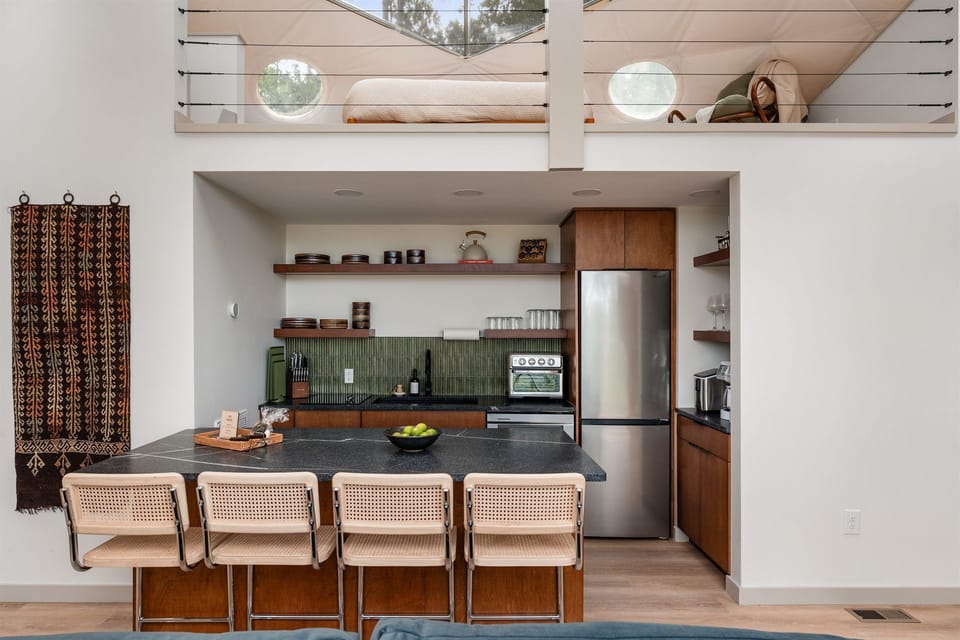 Modern kitchen with island seating and charming dual loft sleeping nooks