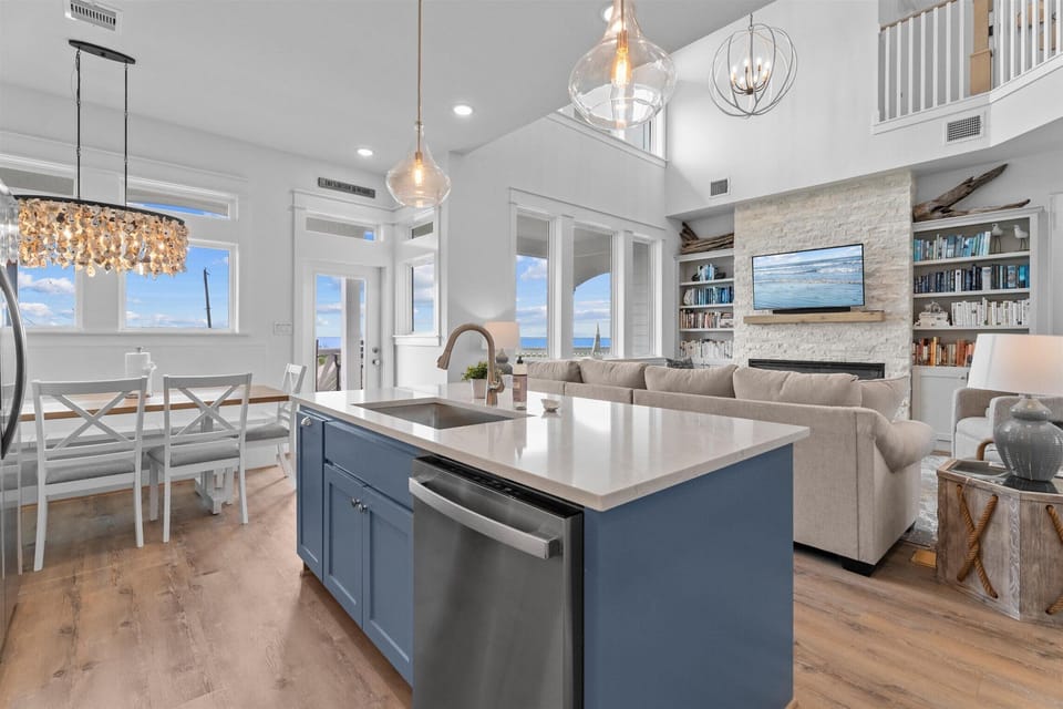 Bright chef's kitchen with waterfall island seating, pendant lighting and open-concept coastal design.