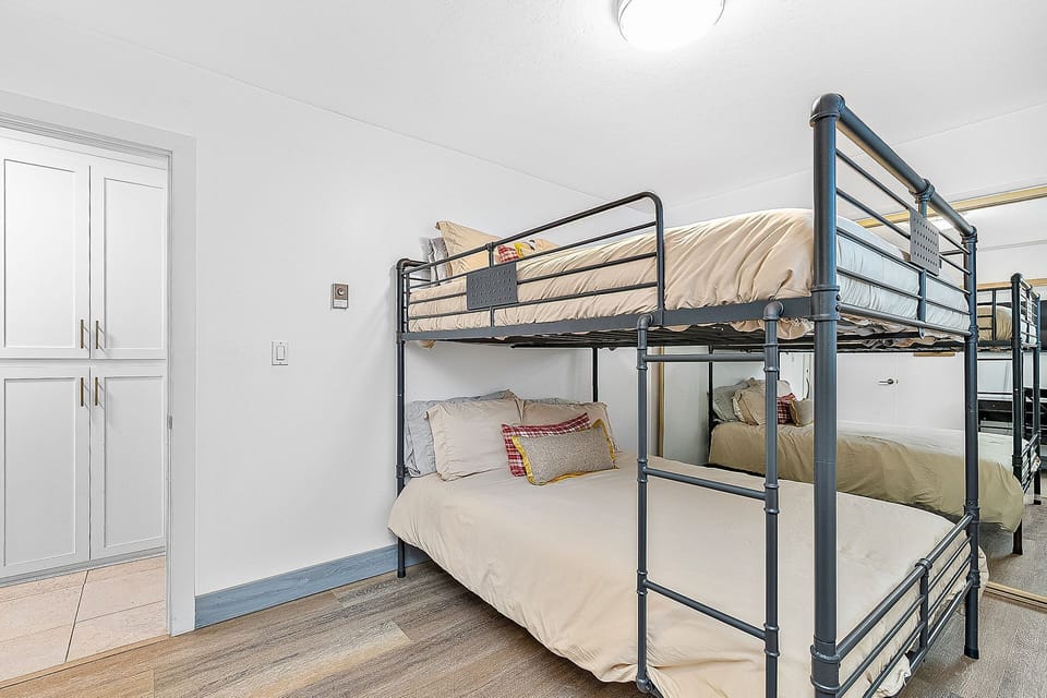 Guest Bedroom 2 featuring queen-size bunk beds and a mirrored closet wall
                