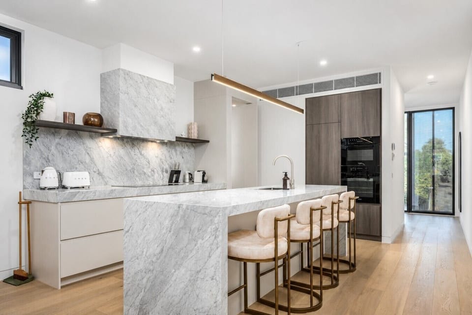 Exquisite marble surfaces pair with premium integrated cooking tech for a high-end stay.