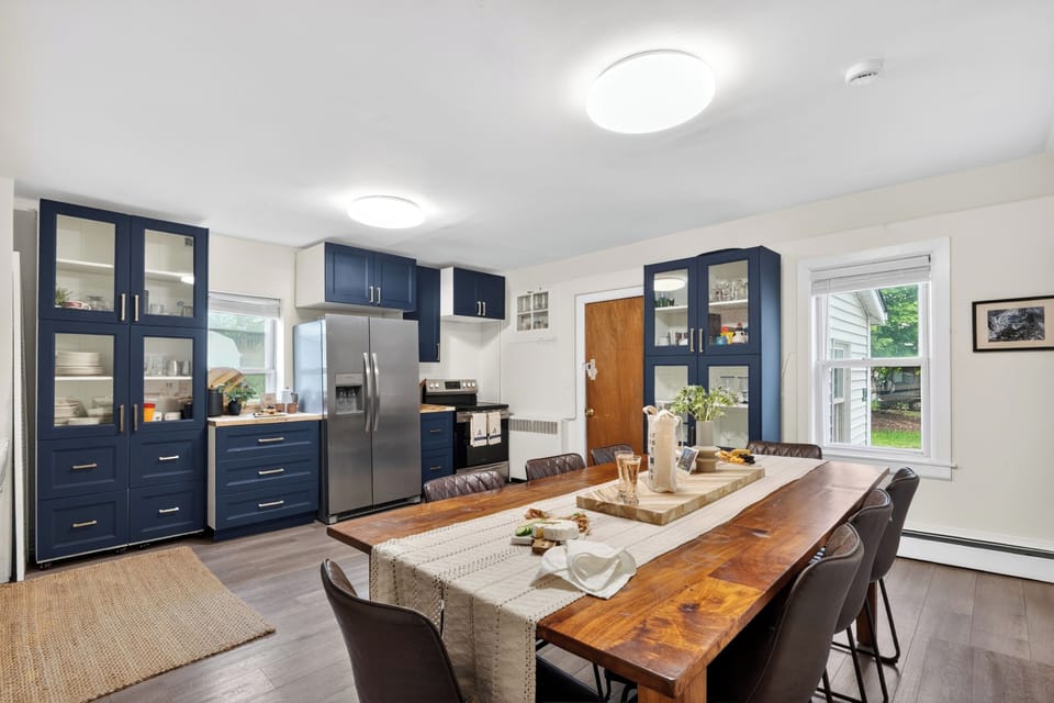 Spacious dining area with rich wood finishes, blue cabinetry, and plenty of seating for gathering over meals and drinks.