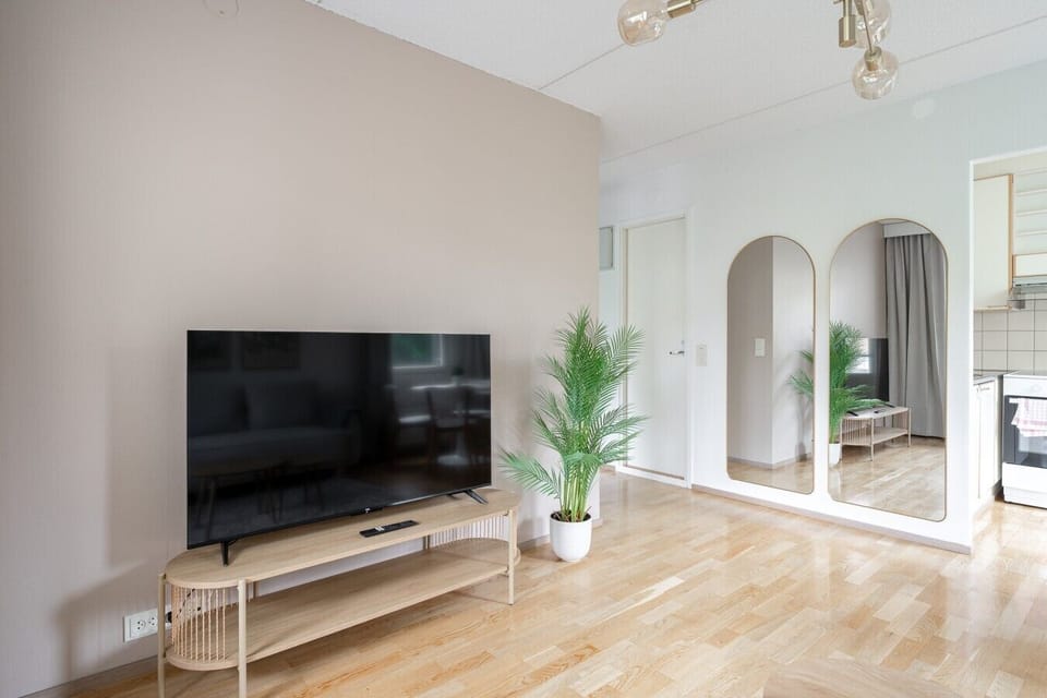Relax in front of the large smart TV after a long day of exploring the city. A sleek, modern setup designed for your comfort.