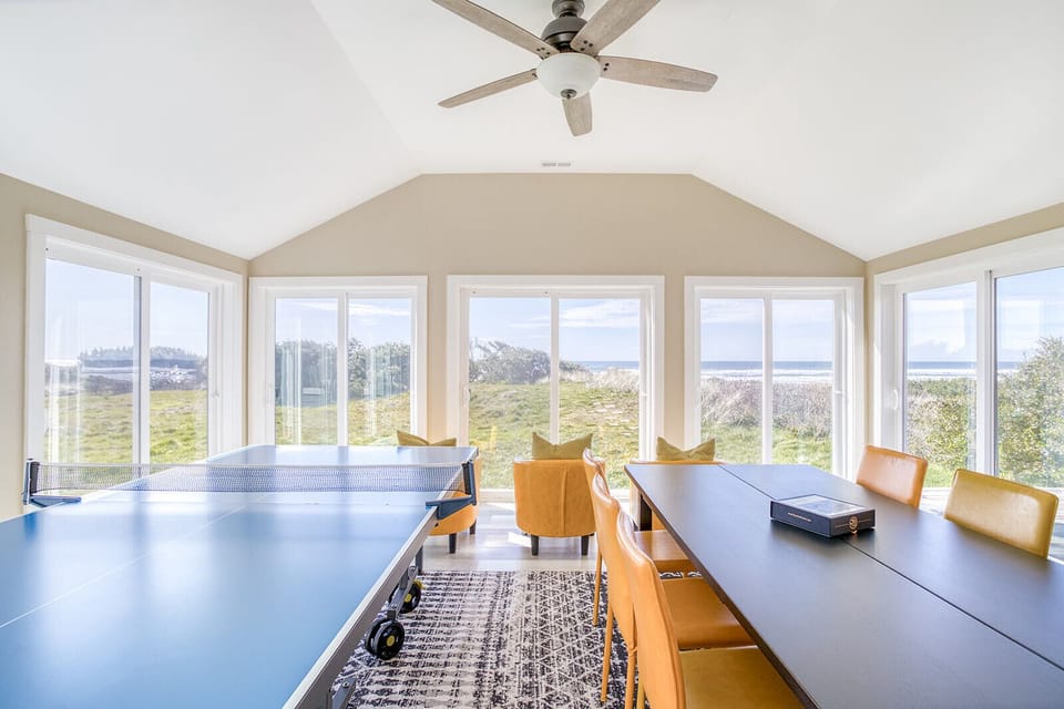 Your bright game room features panoramic windows framing stunning natural views, perfect for friendly table tennis matches and relaxing moments.