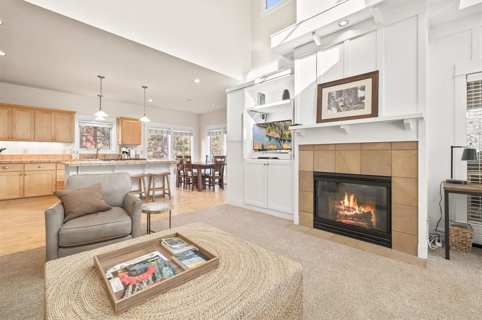 Living room with sectional sofa, fireplace, large smart TV, and a work space.