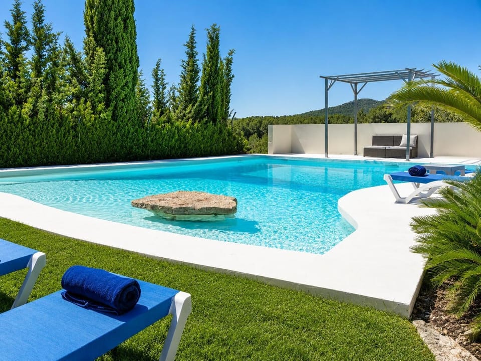 A beautiful private pool surrounded by lush greenery, blue loungers, and peaceful mountain views.
