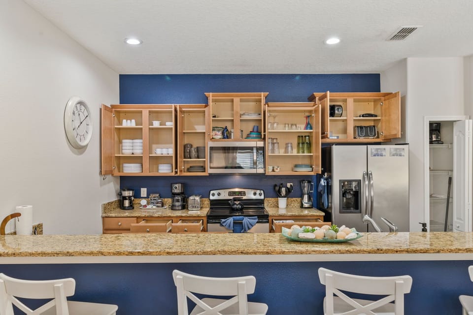 Open kitchen layout with breakfast bar seating and ample storage.