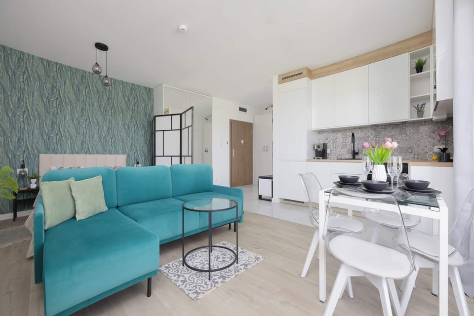 Comfortable studio with turquoise sofa and decorative accent wall