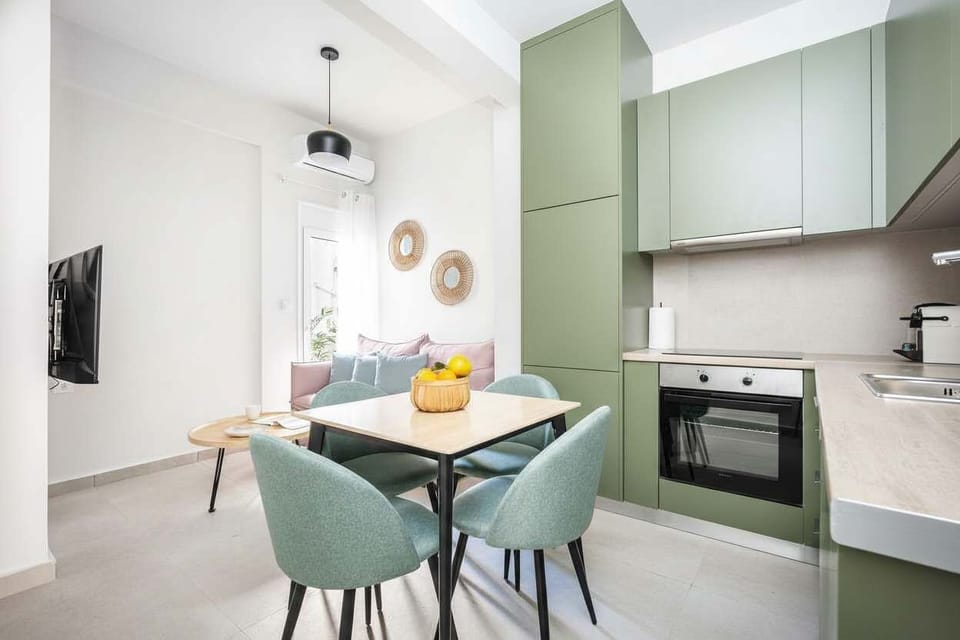 Share meals at the modern dining table, surrounded by soft green cabinetry and warm details that make cooking feel effortless.