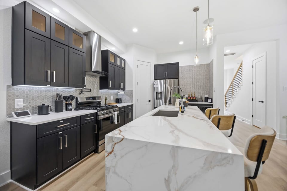 Modern chef’s kitchen with waterfall island and stylish bar seating