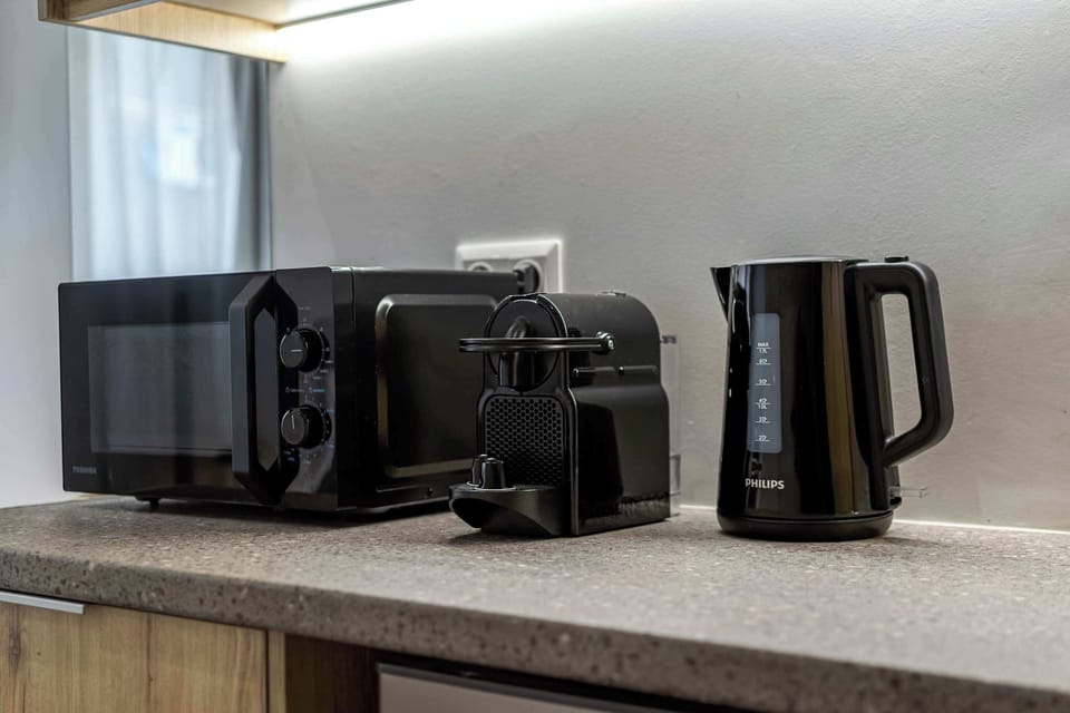 Compact beverage station with espresso machine, kettle, and microwave simplifies mornings and late-night snacks.
