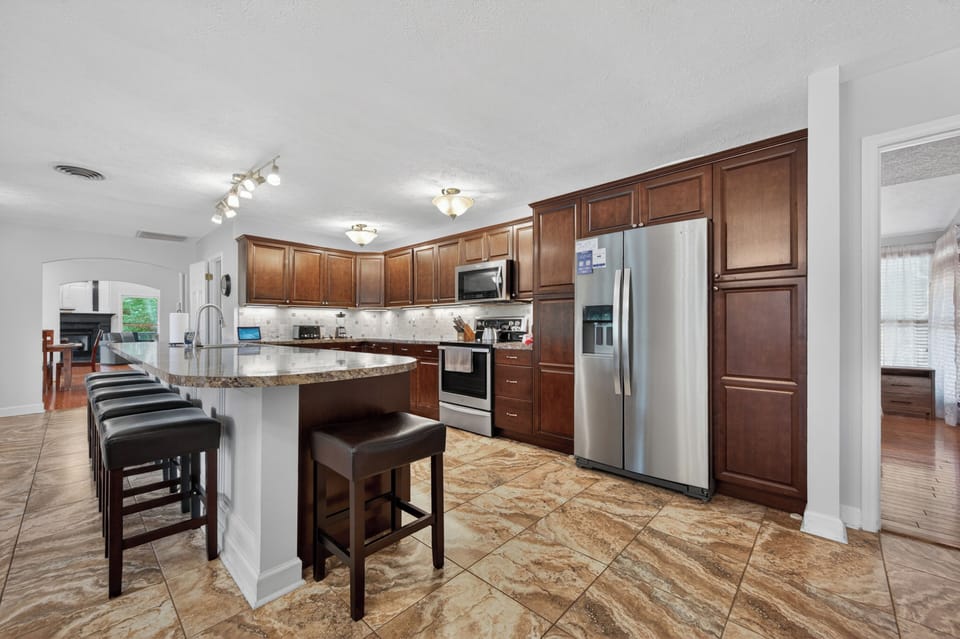 Open-concept kitchen with generous counter space, bar seating, and a spacious layout designed for cooking, dining, and gathering together.
