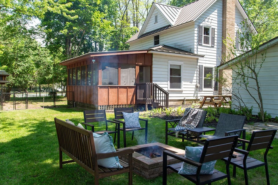 Firepit, grill, and screened in porch in the backyard