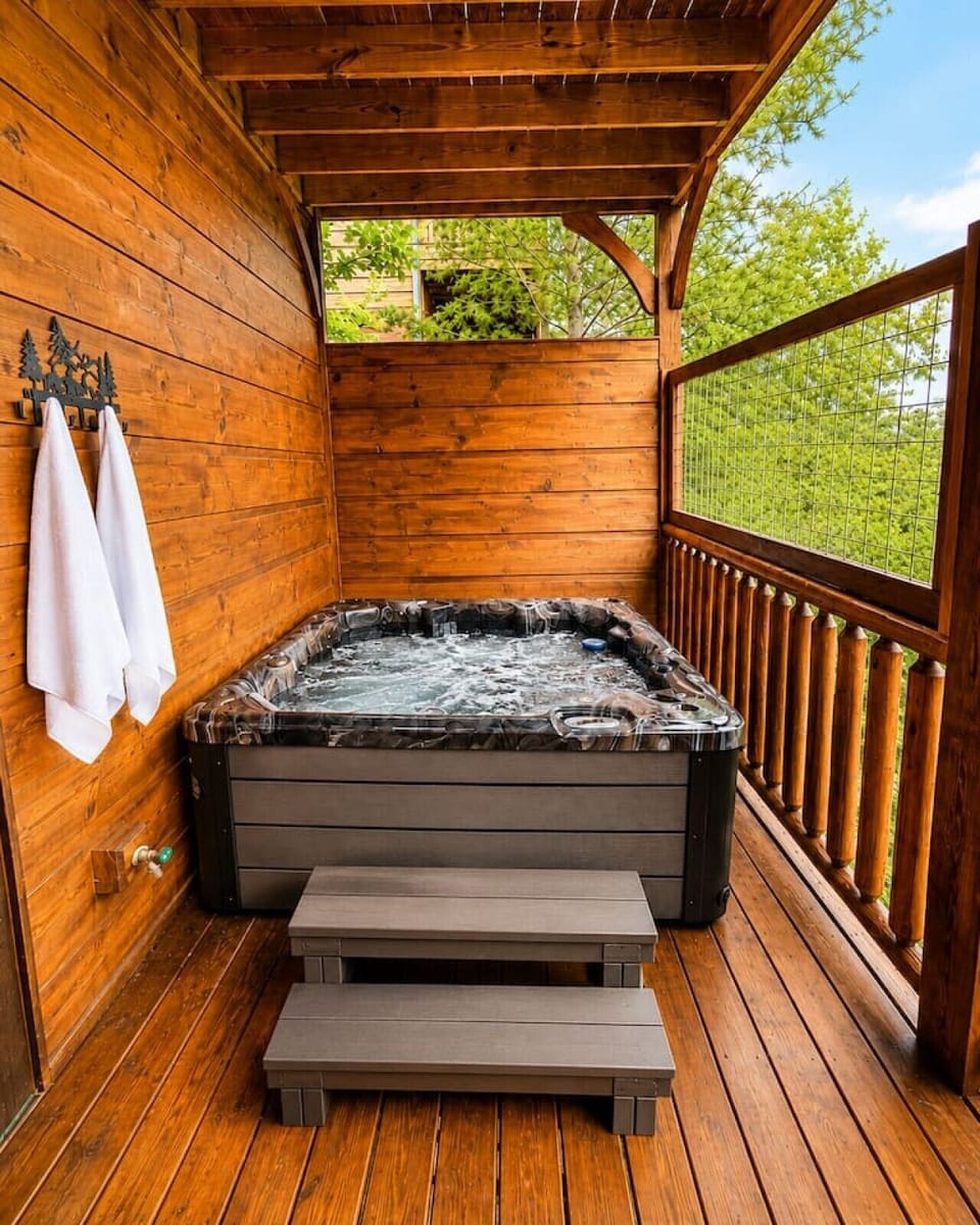 Brand-new private hot tub on covered deck with fresh towels and peaceful wooded surroundings at Views Forever.