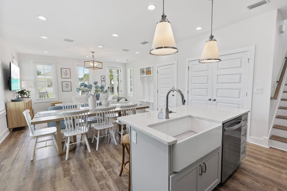 Gather around the spacious dining table under warm pendant lights, then cook together in your fully equipped kitchen with modern appliances and a farmhouse sink.