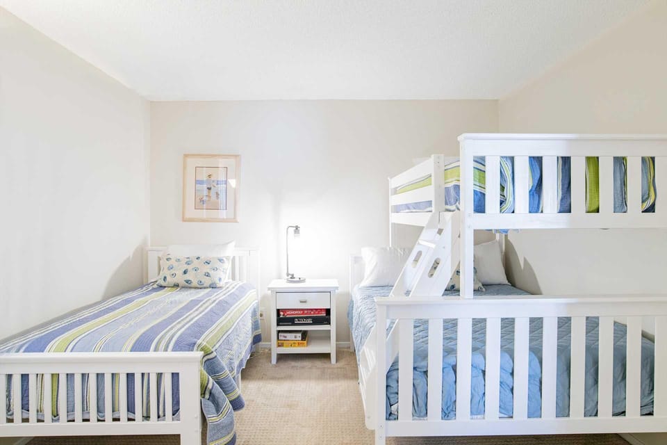 Bright and cozy bedroom with twin and bunk beds for family comfort