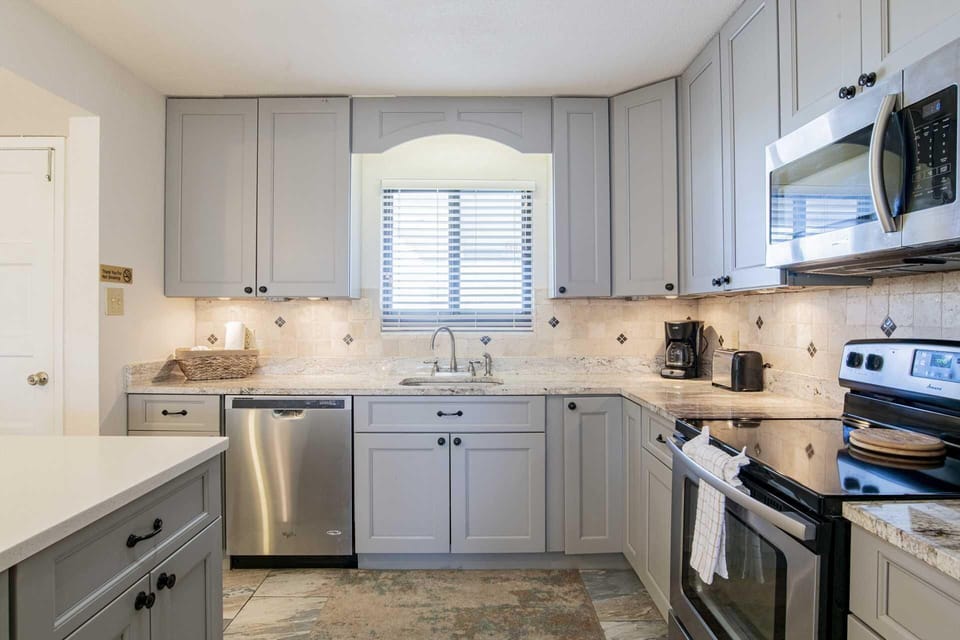 Bright, modern kitchen with stainless steel appliances and cozy window view