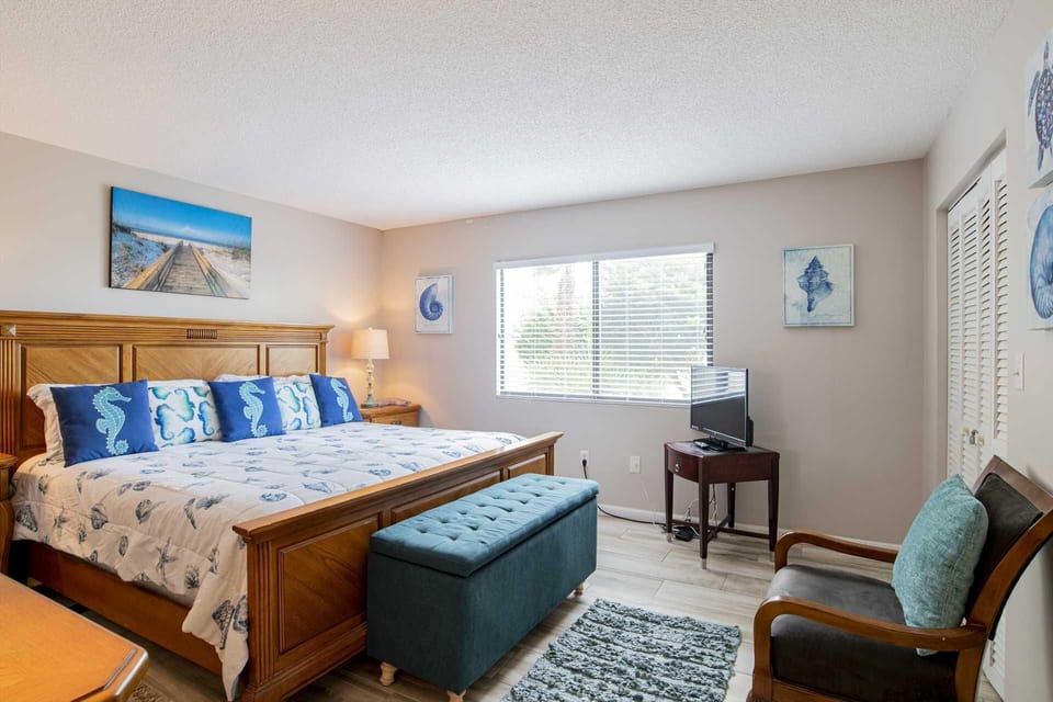 Bright bedroom with serene ocean artwork and natural light