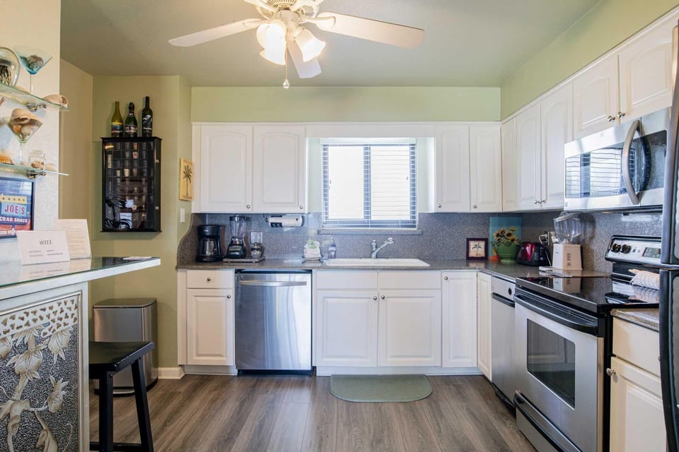 Bright, modern kitchen with stainless steel appliances and cozy breakfast bar