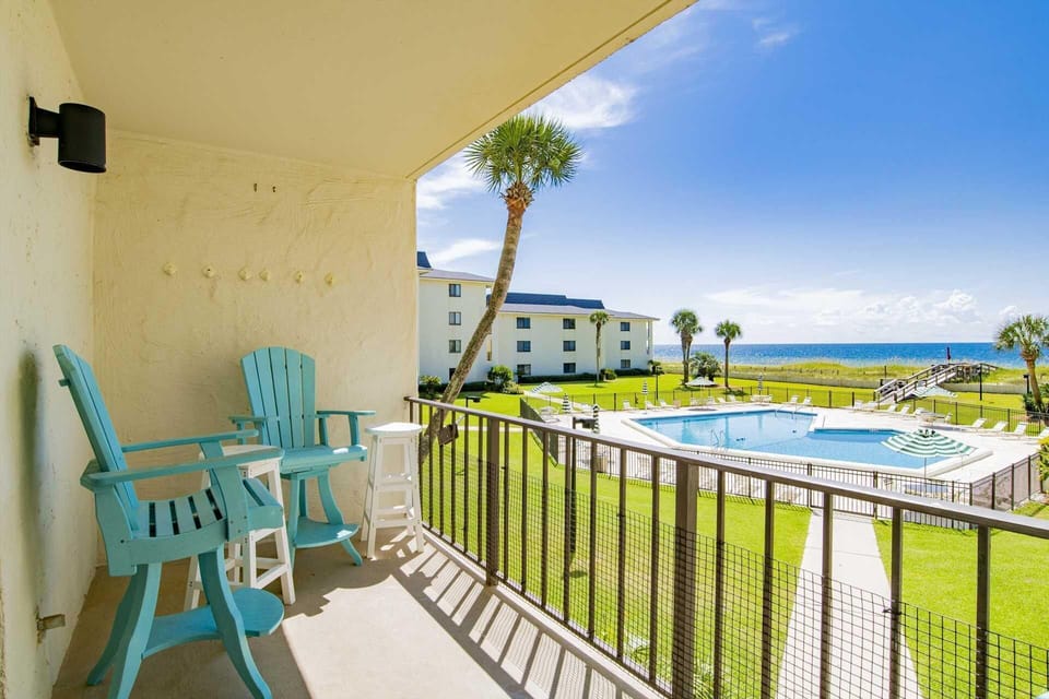 Ocean-view balcony with cozy seating and pool access