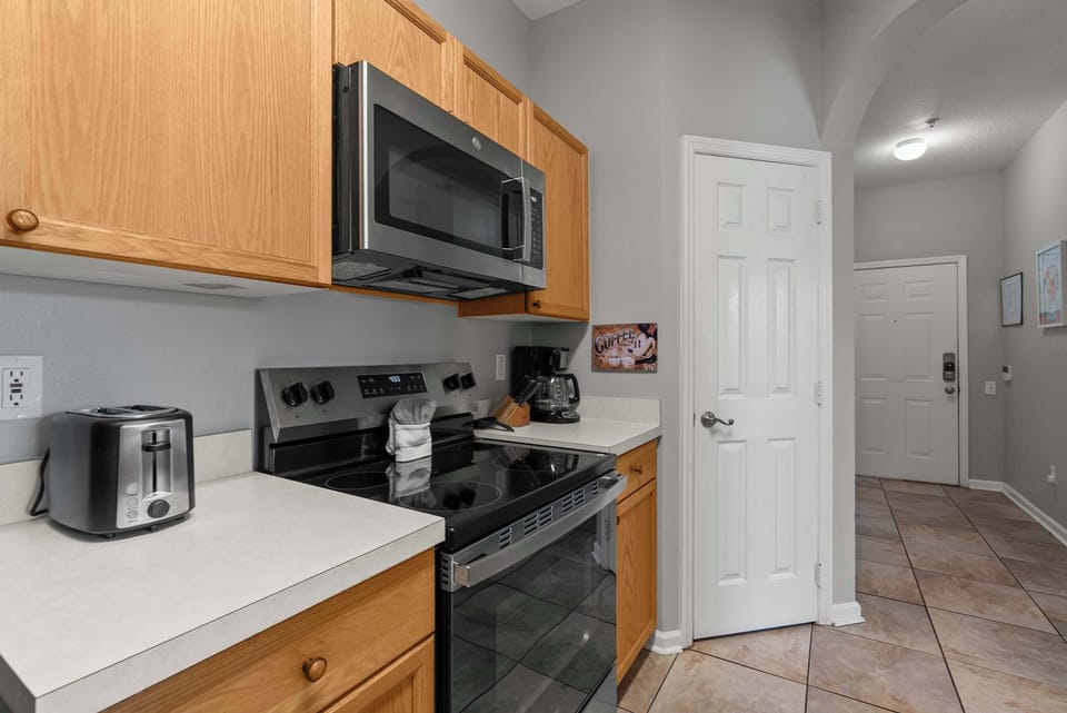 Modern kitchen area featuring stainless steel appliances and wooden cabinetry.