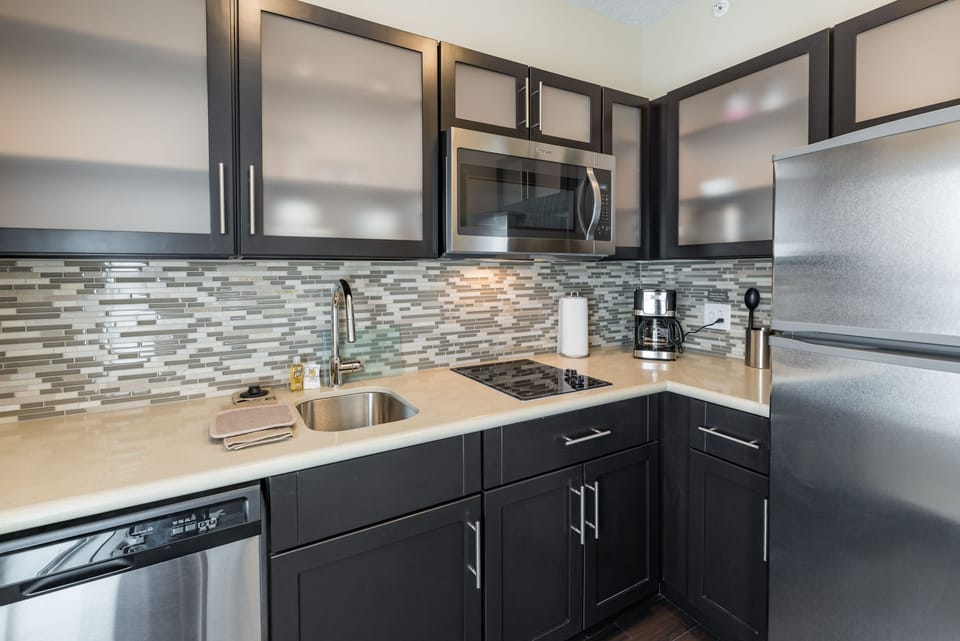 Kitchenette with sleek cabinetry, full appliances, and coffee maker.