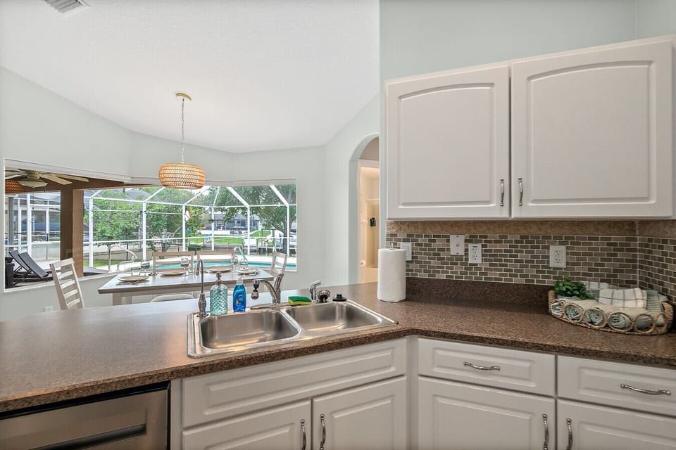 Bright kitchen with pool views, ample counter space, and everything needed for vacation dining.