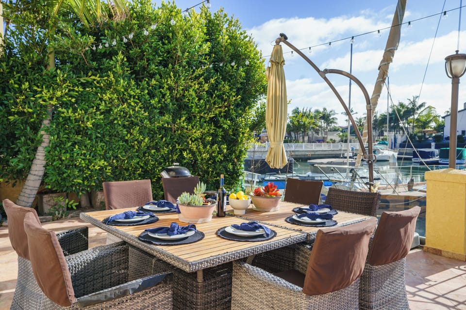 Waterfront patio dining with marina views, string lights, and plenty of space to gather outdoors.