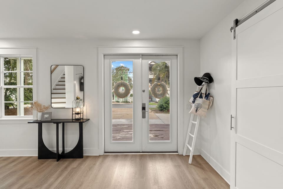 A grand, welcoming entryway features beautiful double doors and bright, modern finishes. (Main-level)