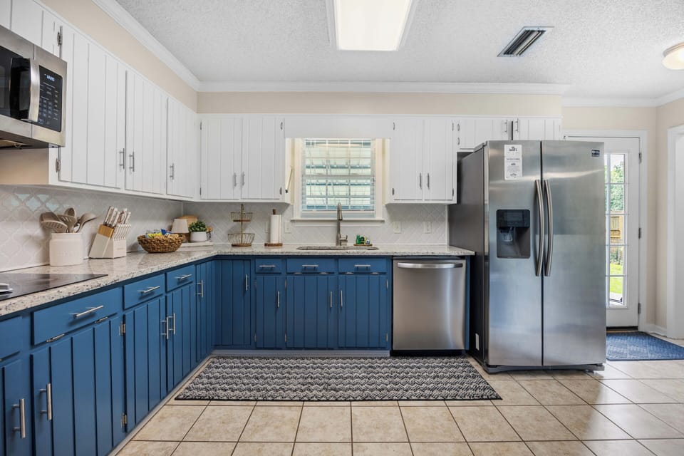 Bright two-tone kitchen with stainless appliances and ample prep space