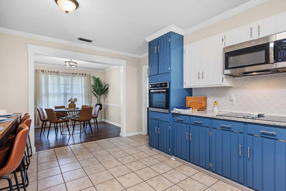Bright updated kitchen with bold blue cabinets and open dining area