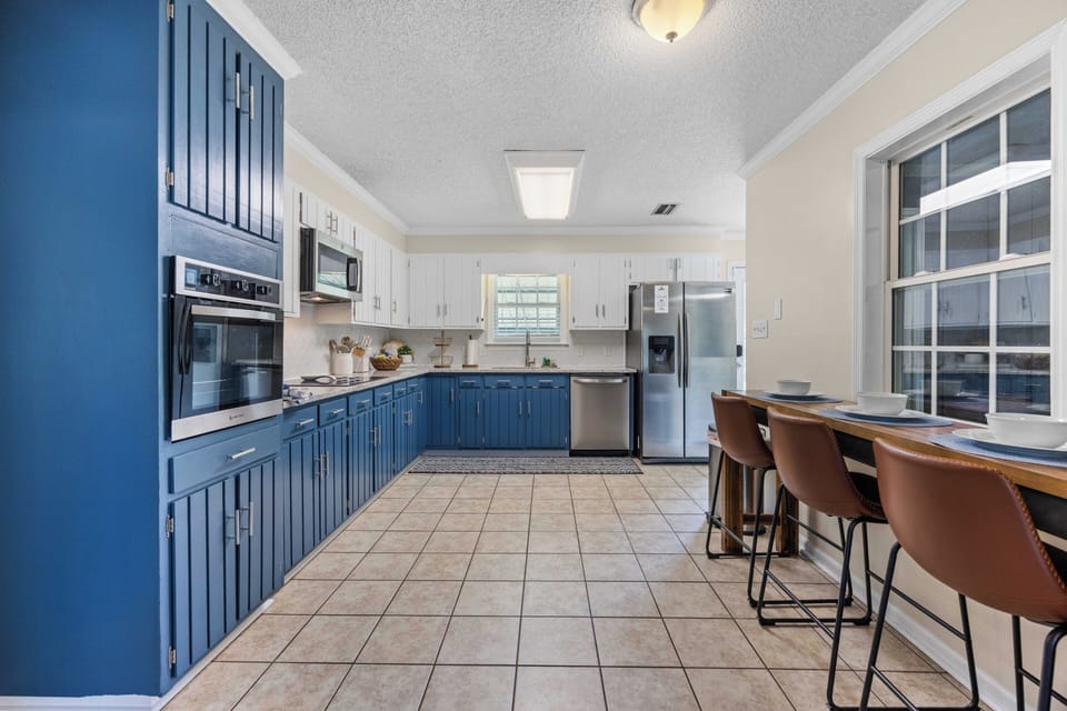 Bright modern kitchen with bold blue cabinets and window-side breakfast bar