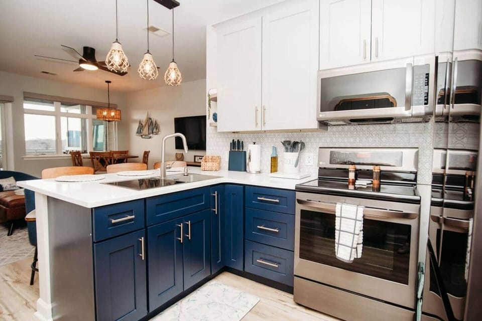 Cook in style in this beautifully updated kitchen with sleek stainless steel appliances, bold two-tone cabinetry, and a large island perfect for meal prep, morning coffee, or evening cocktails.

