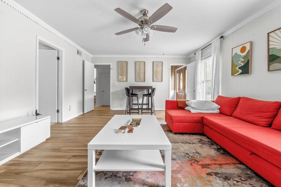 his airy layout seamlessly blends relaxation with functionality. Transition effortlessly from lounging on the plush couch to grabbing a casual bite or setting up your laptop at the stylish dark-wood high-top table, complete with four modern black bar