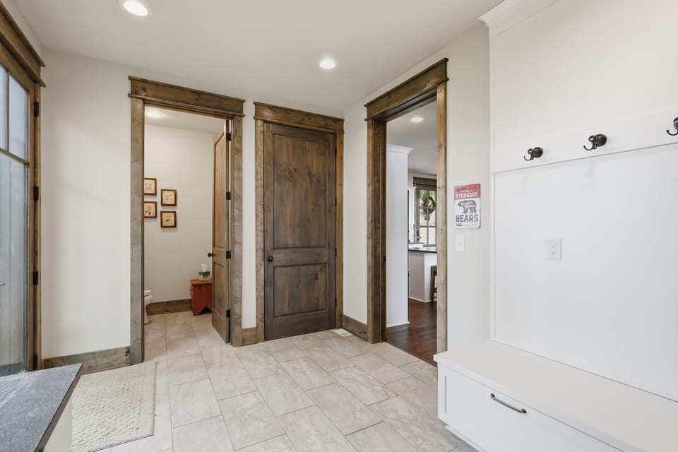 Bright mudroom entry featuring a built-in bench, handy hooks, and rustic wood accents — a stylish, functional spot to drop your gear.