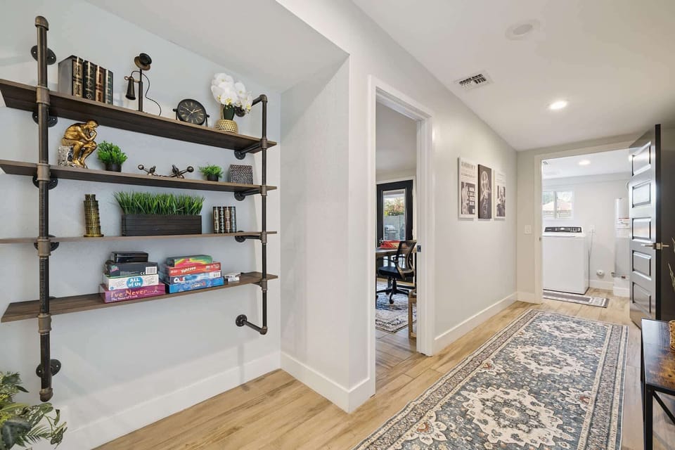 Explore the thoughtful details of our retreat! This bright hallway features custom shelving stocked with games for your next family night. A perfect blend of modern design and practical amenities for your stay.