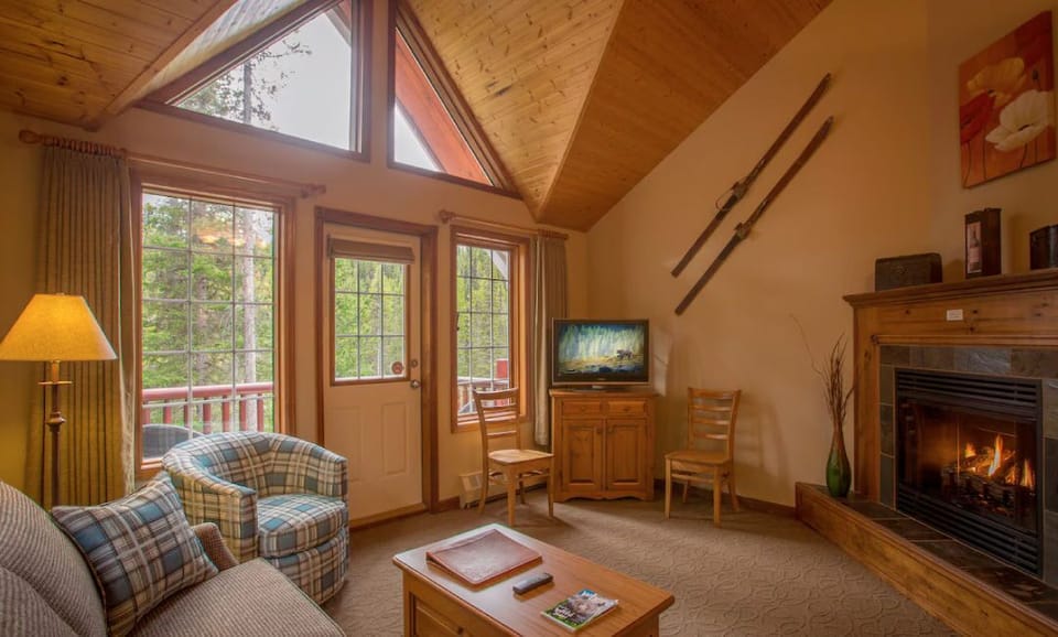 Unwind in the living area beside a gas fireplace, surrounded by large windows letting in natural light.