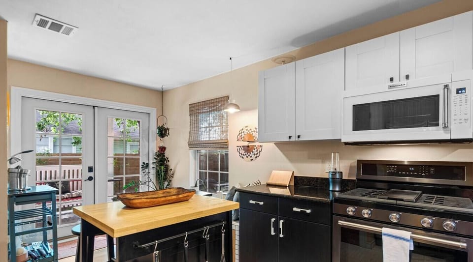 Fire up the KitchenAid gas range in the fully stocked kitchen, with French doors to the deck just steps away.