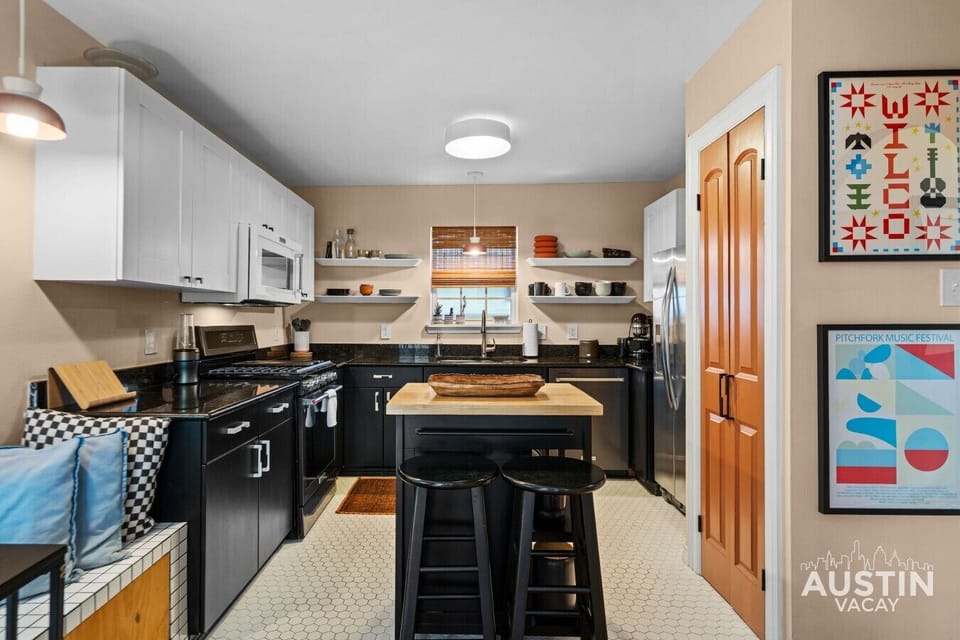 Cook in the bright kitchen with gas range, granite counters, and a butcher-block island with bar seating.