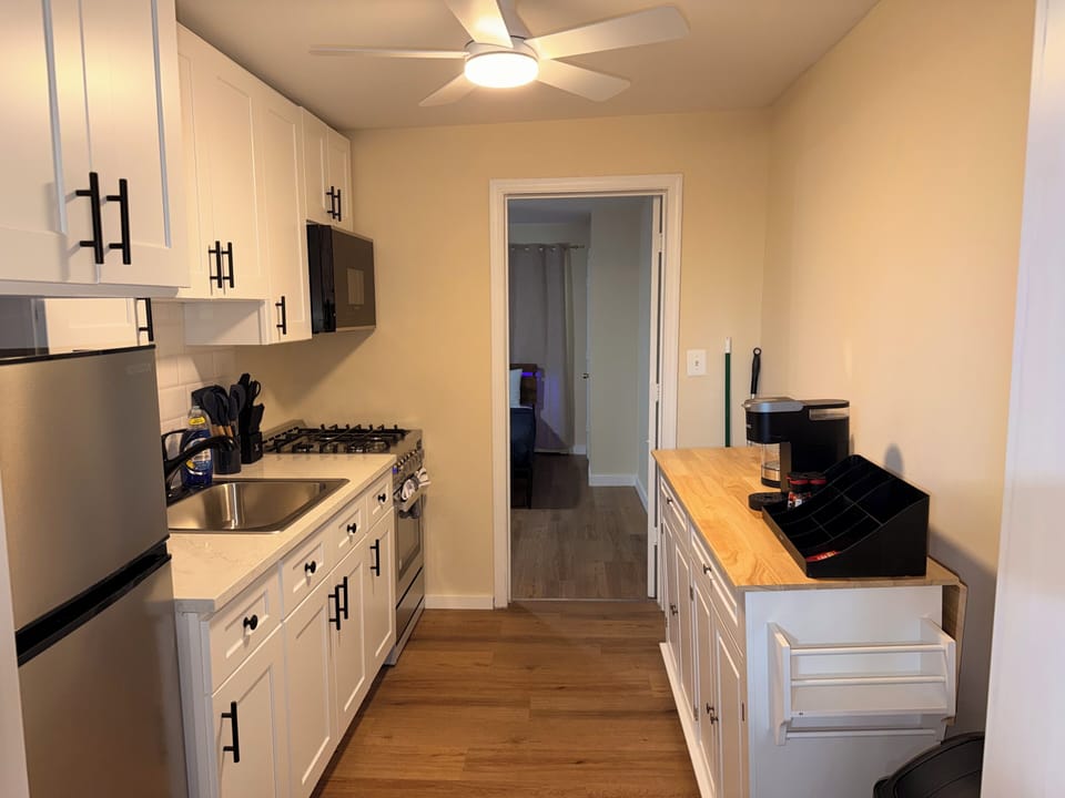 Bright updated galley kitchen with gas range, coffee station, and modern finishes