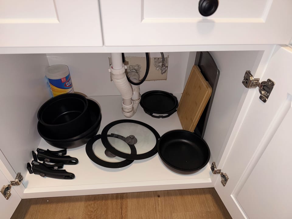 Well-stocked kitchen storage with cookware, knives, and prep essentials