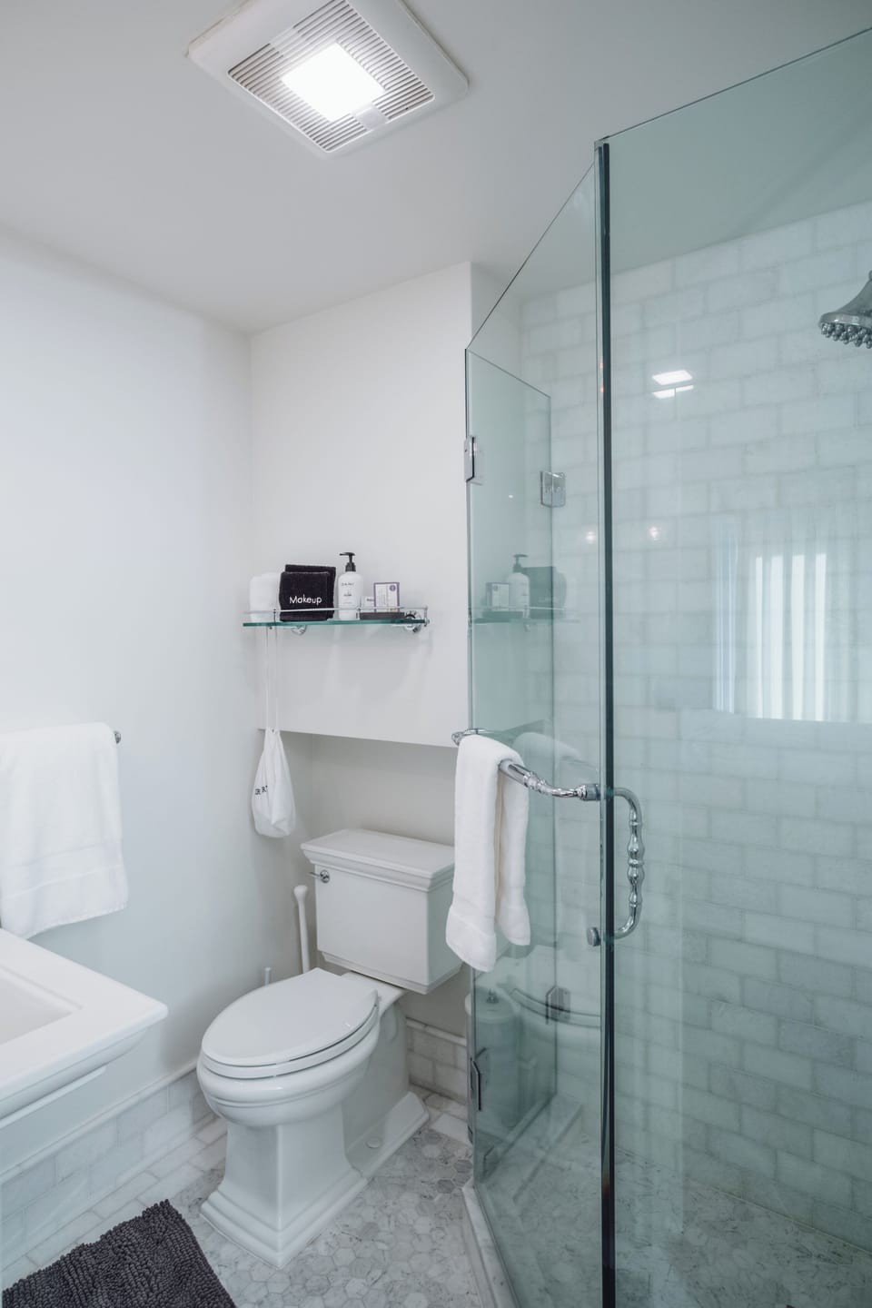 Bright modern bathroom with glass walk-in shower and elegant white finishes