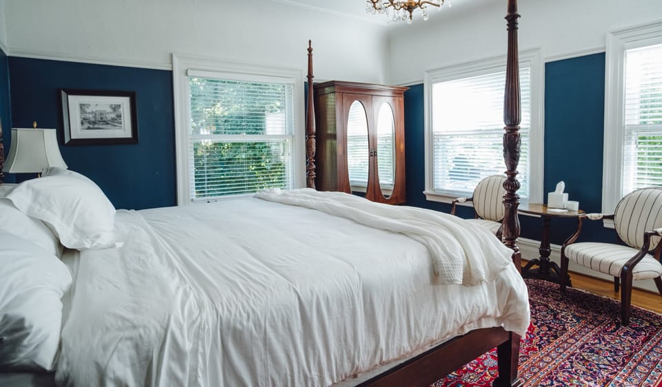 Elegant four-poster bedroom with natural light and timeless vintage charm