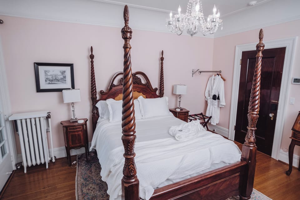 Elegant four-poster bedroom with chandelier and boutique-style charm